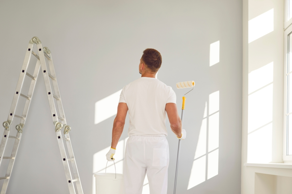 Malermeister steht vor einer Wand