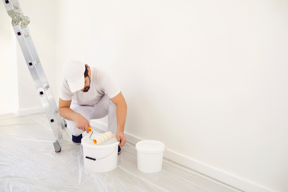 Malermeister bereitet Grundierung vor für die Wohnzimmerwand Malermeister bereitet Grundierung vor für die Wohnzimmerwand