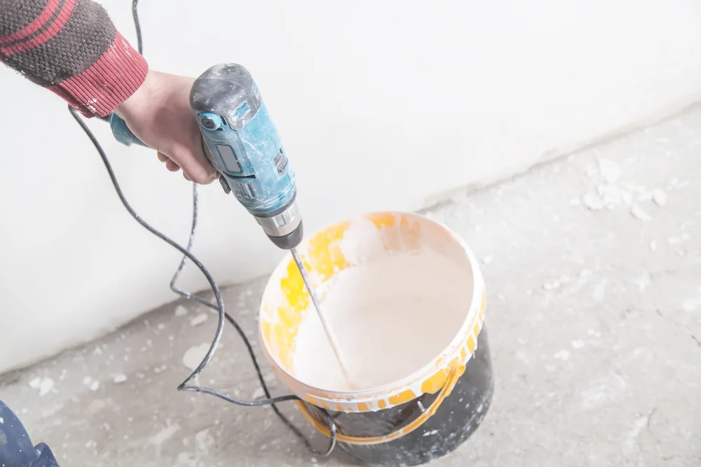 Professioneller Handwerker, der Tapeten entfernt Maler mischt ökologische Wandfarbe schadstofffrei